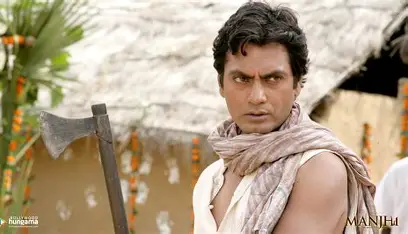 Nawazuddin Siddiqui in "Manjhi", embodying defiance as he holds an axe, pivotal to discussions of Bollywood piracy scandals due to illicit distribution.