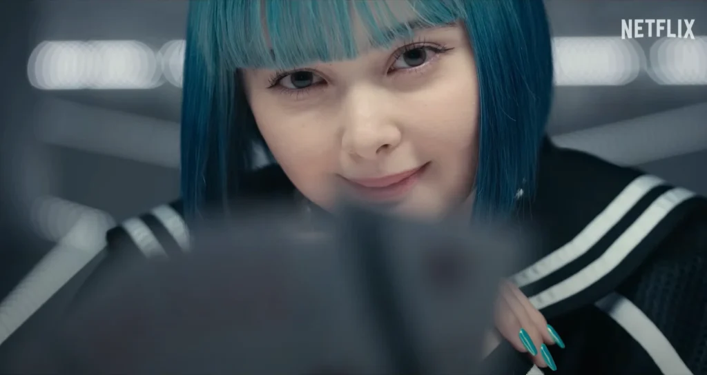 Close-up of a young woman with turquoise hair and a slight smile, looking at a tablet.