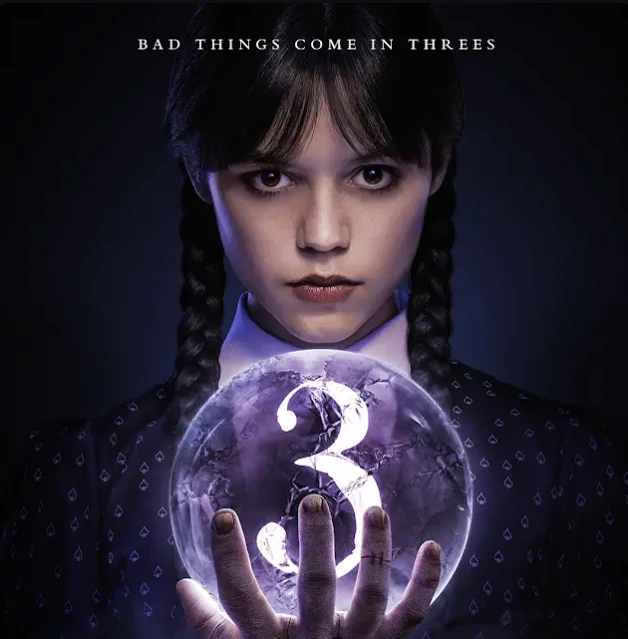 Promotional art for Wednesday Season 3, focusing on Wednesday Addams holding a glowing orb with the number "3" inscribed. Wednesday has a serious, direct expression, and the orb symbolizes the upcoming season. "Bad things come in threes" text is displayed above her head.