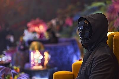 The Frontman from the series Squid Game is seated in profile, wearing a matte black hooded cloak and triangular mask.
