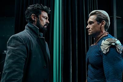 A still from The Boys season 4 spoiler-free review: Billy Butcher, wounded and wearing a dark coat, stands opposite Homelander. Homelander, in his superhero costume, has a focused expression. Vertical teal and black curtains are in the background.