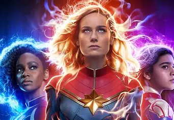 Movie poster featuring Captain Marvel, Kamala Khan, and Monica Rambeau with intense gazes, surrounded by radiant energy in gold, blue, and magenta hues.