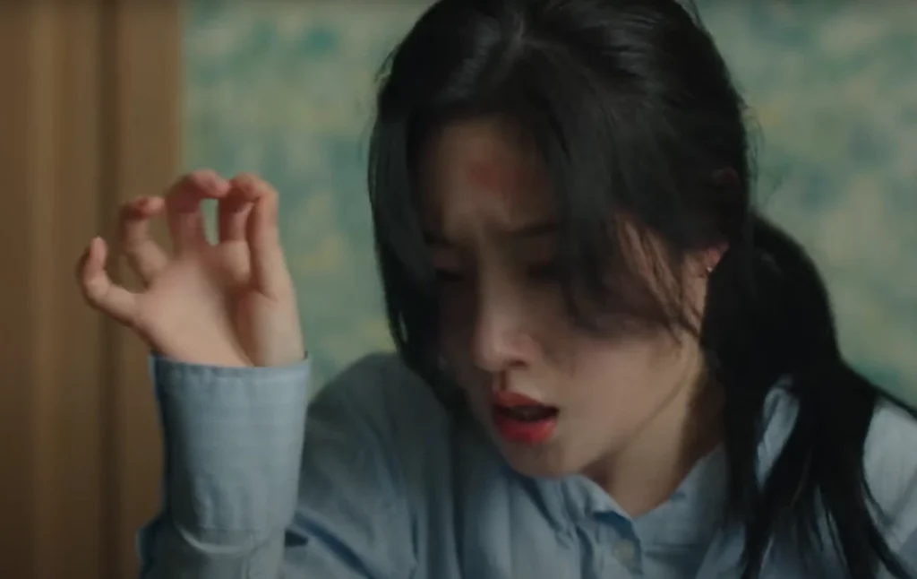 A young woman with dark hair, wearing a light blue shirt, looks distressed with a red mark visible on her forehead; a still from a K-Drama on Netflix. This is related to Top 5 Must-Watch K-Dramas on Netflix in 2025.