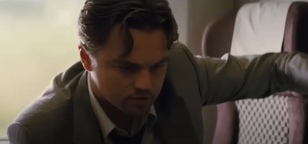 A low-angle, close-up view of an individual with a serious expression, dressed in a suit, looking down. The seat behind them is visible. This image would typically be associated with top movies for US and UK audiences, particularly those featuring dramatic or intense scenes.